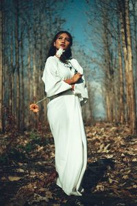 Full length of woman standing in forest