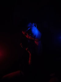 Close-up of illuminated man in darkroom