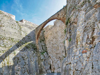 Low angle view of weathered wall against sky