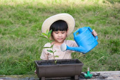 Portrait of cute boy watering plants