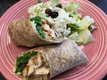 Close-up of chicken wrap with salad on plate