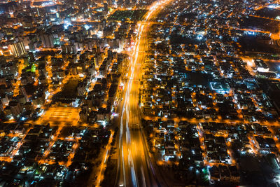 High angle view of illuminated street amidst buildings at night