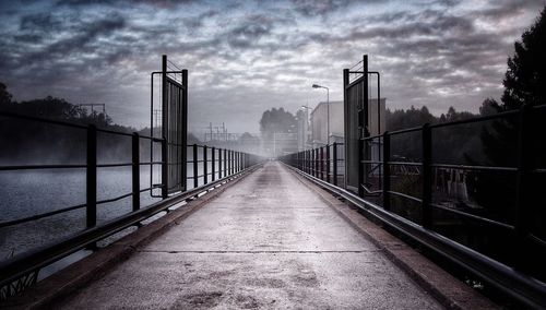 Bridge against cloudy sky