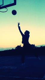 Silhouette man jumping against clear sky during sunset