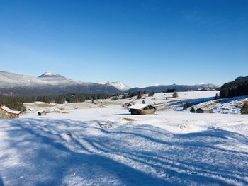 Scenic view of snowcapped mountains against clear blue sky