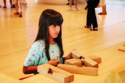 Cute girl looking away at wooden table