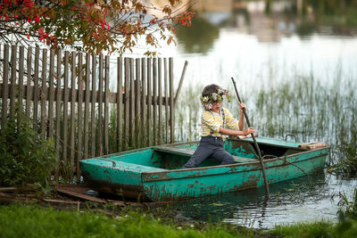 Boy sitting on boat in lake