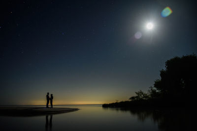 Scenic view of lake against sky at night