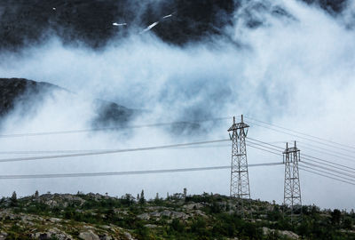 Low angle view of electricity pylon against sky