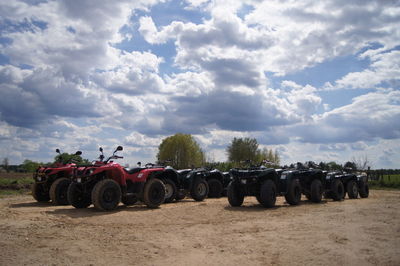 View of field against cloudy sky