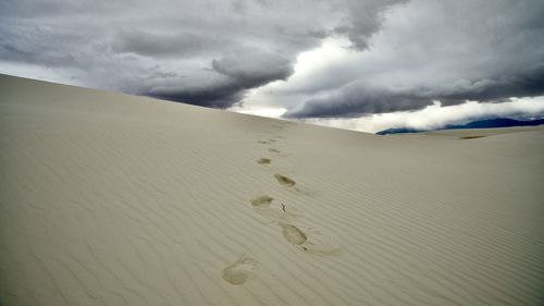 Sand dunes in desert against sky