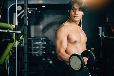Shirtless man exercising in gym