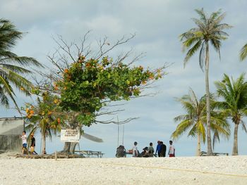 People at beach against sky