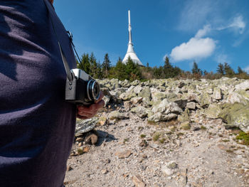 Man takes photo by classic film vintage camera on jested mountain. jested hotel in the background