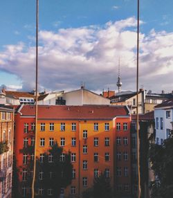 Buildings in city against cloudy sky