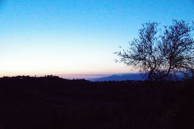 Silhouette landscape against clear blue sky