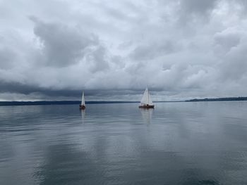 Sailboats in sea against sky