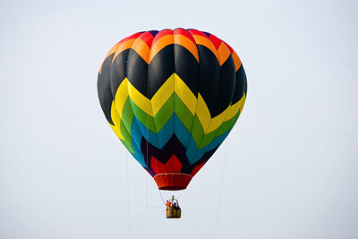 Low angle view of colorful hot air balloons flying against clear sky