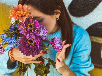 Midsection of woman holding purple flowering plant