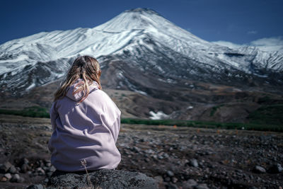 Man standing on snowcapped mountain against sky