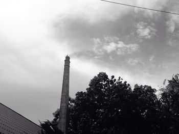 Low angle view of tower against cloudy sky