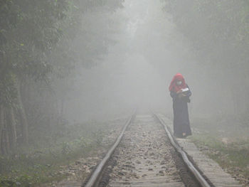 Woman standing on railroad track