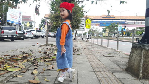 Gril standing on footpath in city