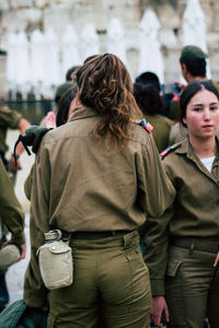 Rear view of people standing in city