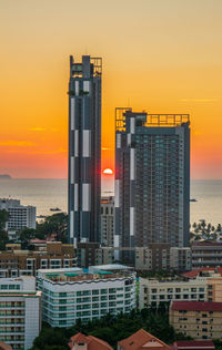 Skyscrapers in city against sky during sunset