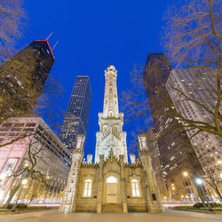 Low angle view of illuminated building against blue sky