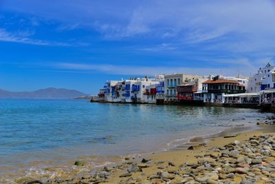 Scenic view of sea by buildings against sky