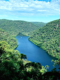 High angle view of lake amidst trees against sky