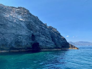 Scenic view of sea and mountains against blue sky