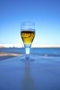 Close-up of drink on table against blue sky