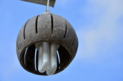 Low angle view of electric lamp against blue sky