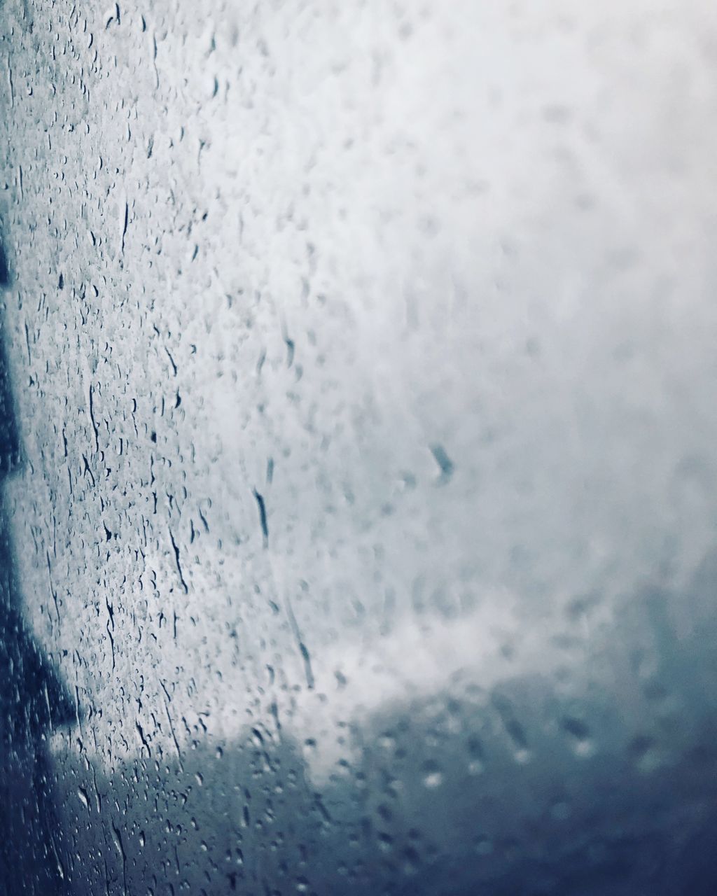 CLOSE-UP OF RAINDROPS ON GLASS WINDOW