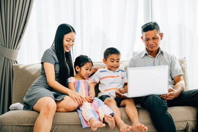 Friends using laptop at home