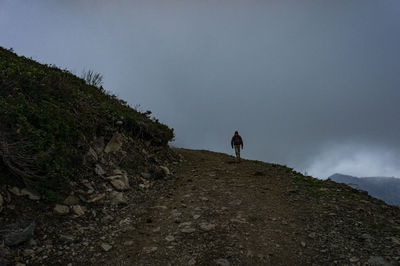 Man standing on mountain against sky