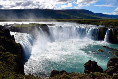 Scenic view of waterfall against sky