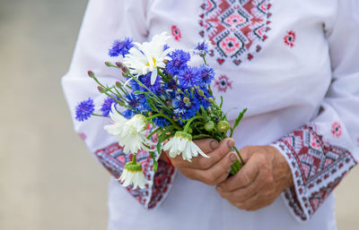 Midsection of bride holding bouquet