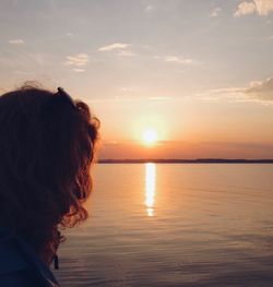 Man looking at sea against sky during sunset