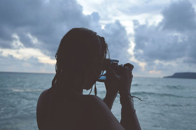 Woman photographing calm sea