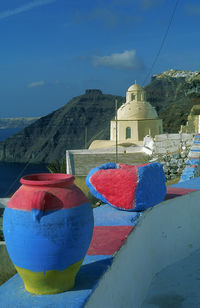 Multi colored umbrellas by building against blue sky