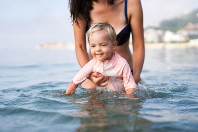 Portrait of young woman swimming in sea