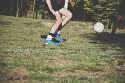 Low section of man playing soccer on field