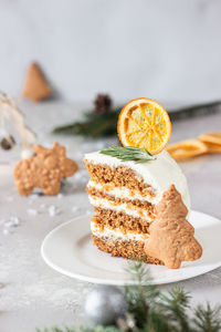 Christmas or new year gingerbread cake decorated with cookies, spices and dried orange slice. 