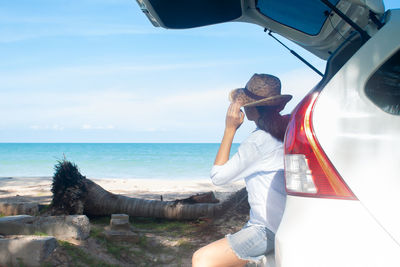 Side view of woman looking at sea against sky