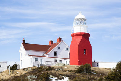 Low angle view of building and lighthouse against sky