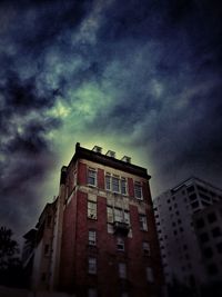 Low angle view of buildings against cloudy sky