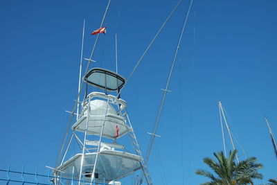 Low angle view of crane against clear blue sky